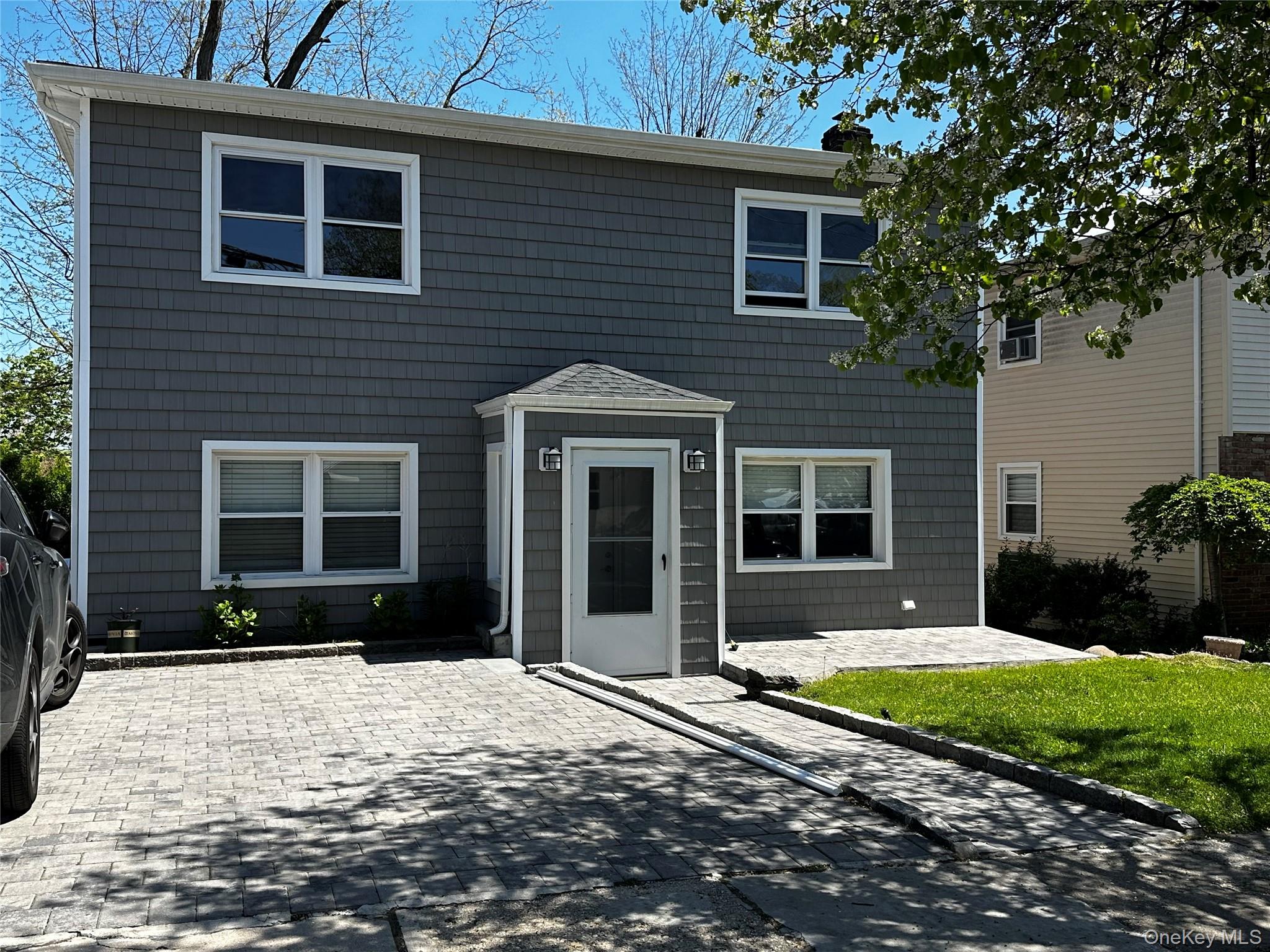 56 Marwood Road North, Unit 2 Port Washington, NY 11050 - Photo 1 of 11 a front view of a house with a yard
