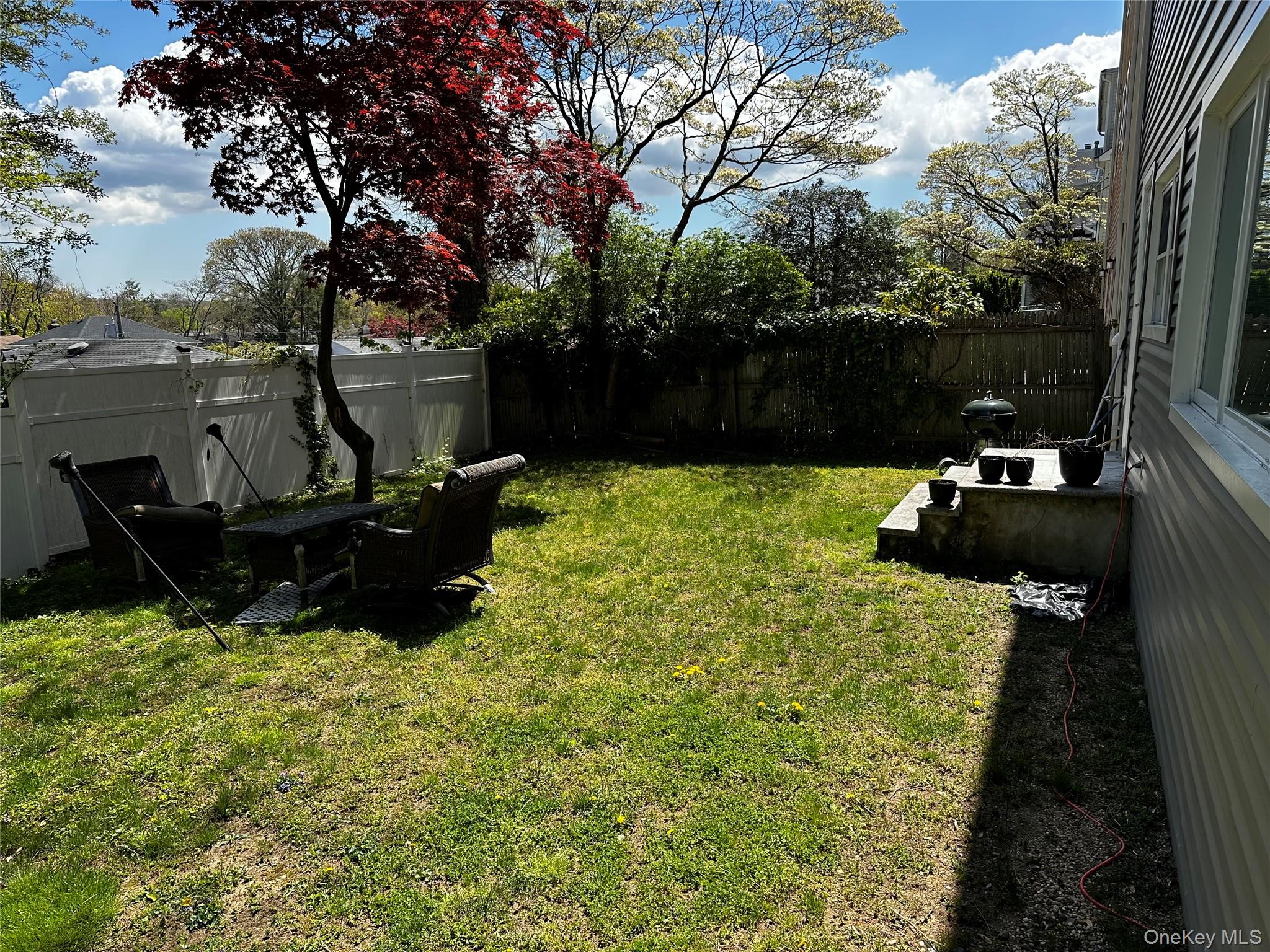 56 Marwood Road North, Unit 2 Port Washington, NY 11050 - Photo 11 of 11 a backyard of a house with yard and outdoor seating