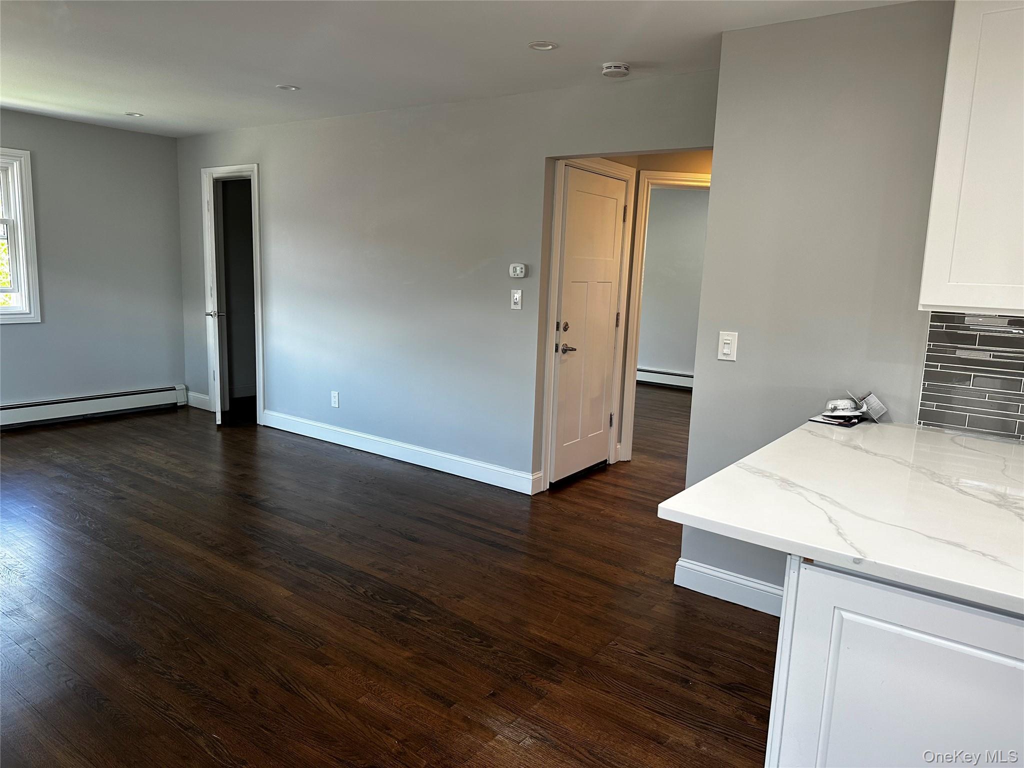 56 Marwood Road North, Unit 2 Port Washington, NY 11050 - Photo 4 of 11 an empty room with wooden floor and bathroom