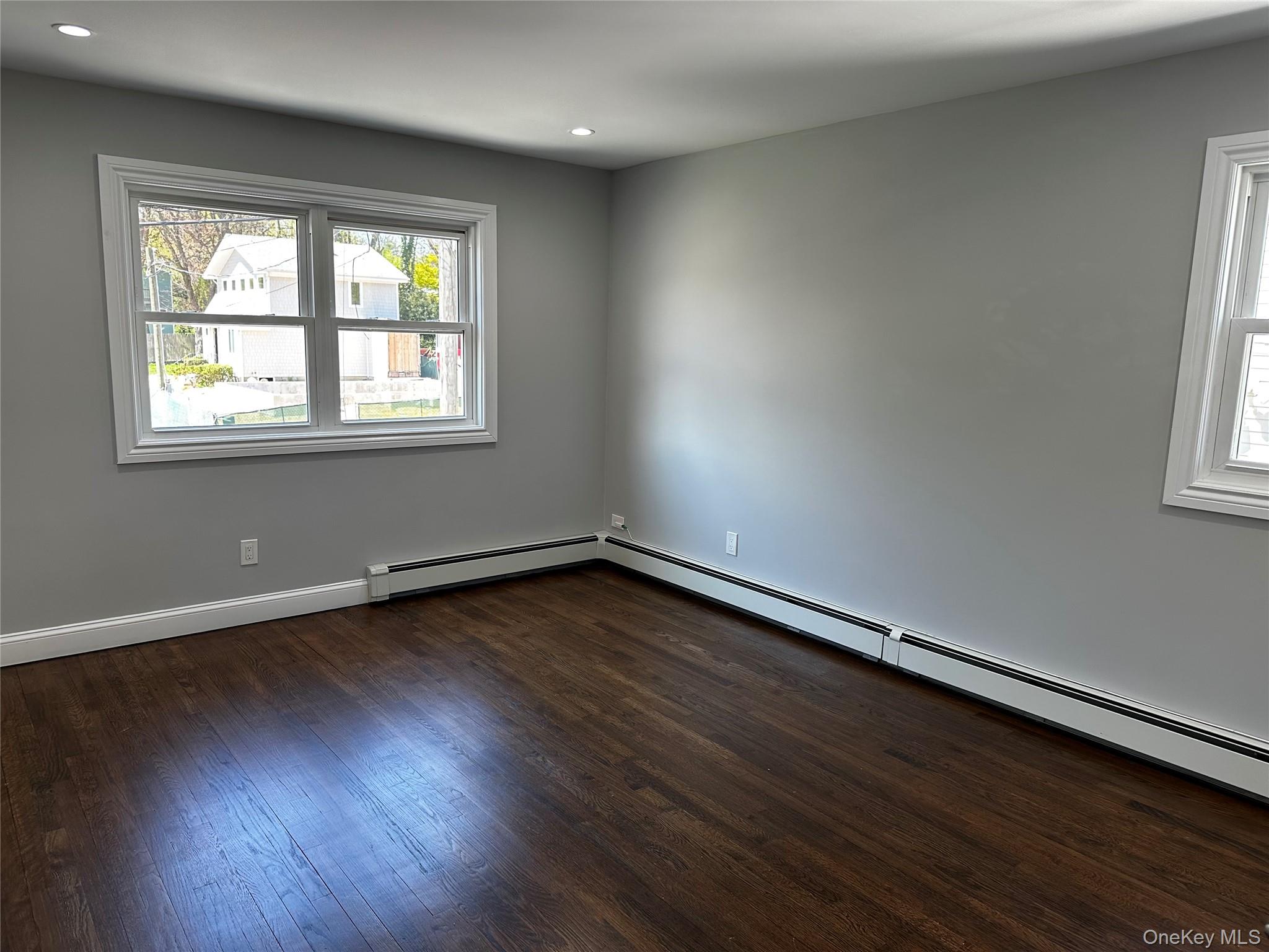 56 Marwood Road North, Unit 2 Port Washington, NY 11050 - Photo 5 of 11 an empty room with wooden floor and windows
