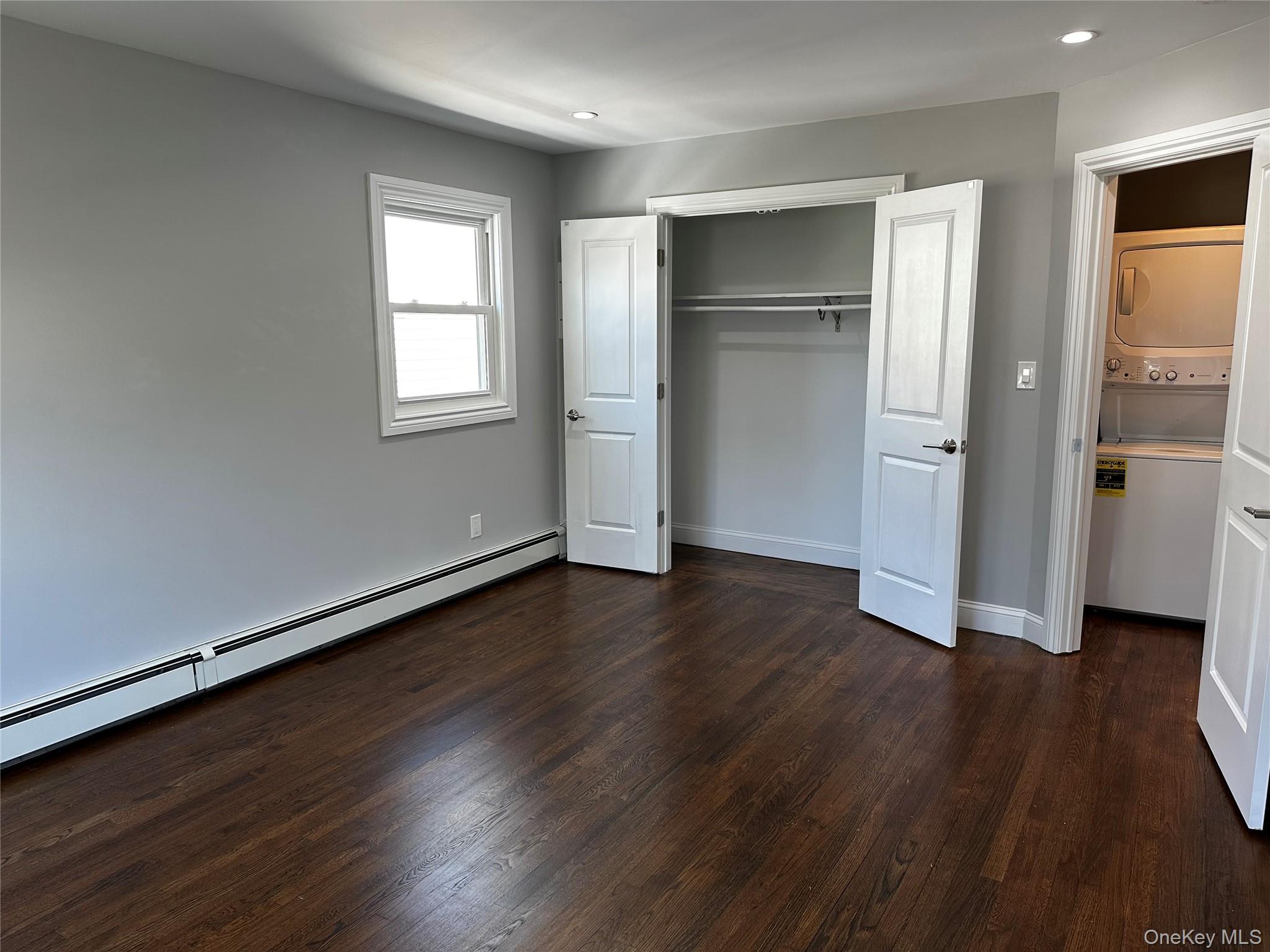 56 Marwood Road North, Unit 2 Port Washington, NY 11050 - Photo 6 of 11 an empty room with wooden floor & windows