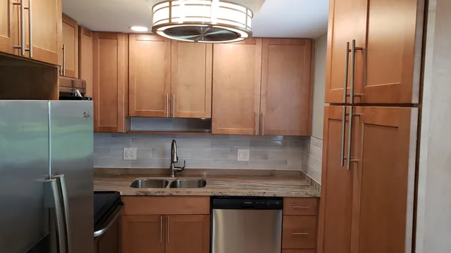 a kitchen with a sink a refrigerator and cabinets