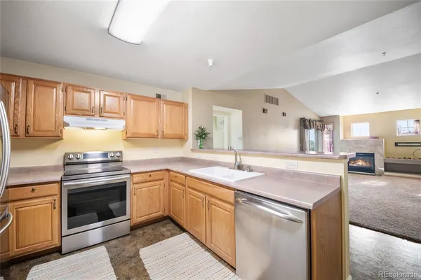 a kitchen with granite countertop a sink and a stove