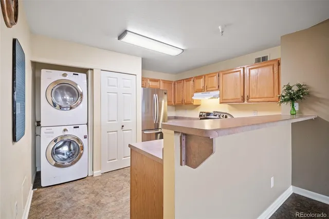 a room with kitchen island a stove a washer and dryer