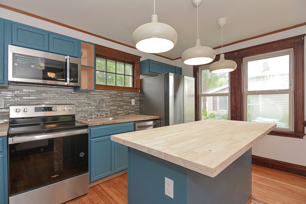 a kitchen with stainless steel appliances a stove a sink island and a refrigerator