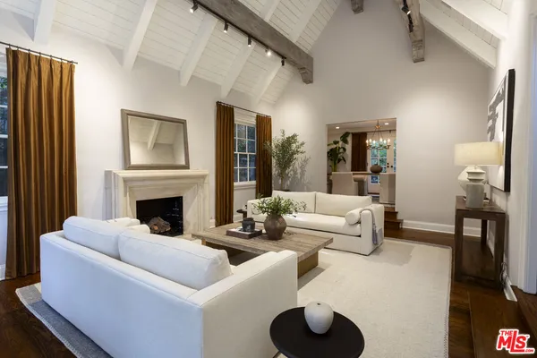 a living room with furniture a fireplace and a large window