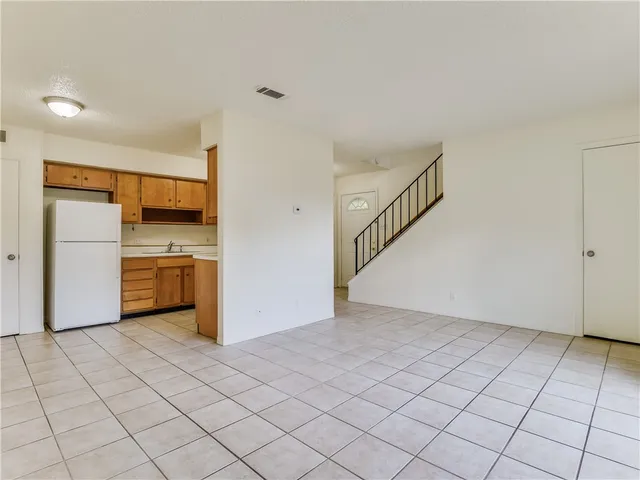 a view of a kitchen with a sink and an empty room