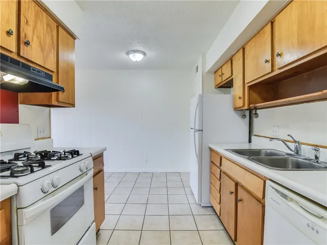 a kitchen with granite countertop a sink stove and cabinets