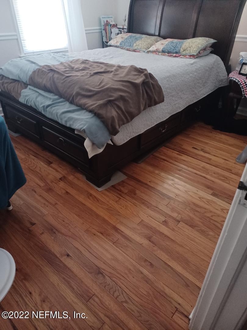 4808 Dundee Road Jacksonville, FL 32210 - Photo 6 of 7 a bedroom with a bed and wooden floor