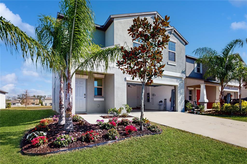 a front view of a house with a garden and trees