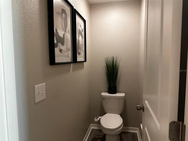 a white toilet sitting next to a shower
