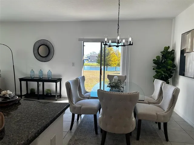 a dining room with furniture a floor to ceiling window and potted plants