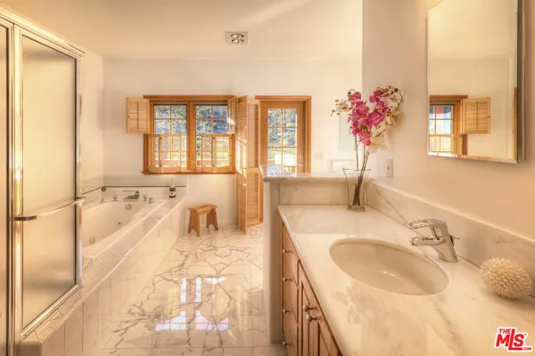 a spacious bathroom with a granite countertop tub sink and mirror