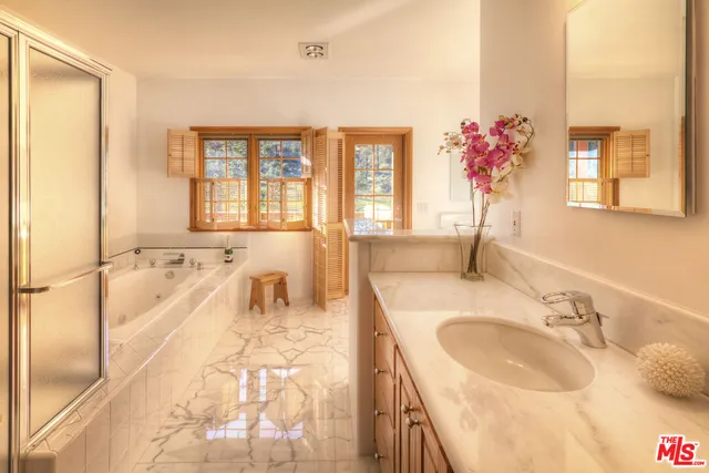 a spacious bathroom with a granite countertop tub sink and mirror