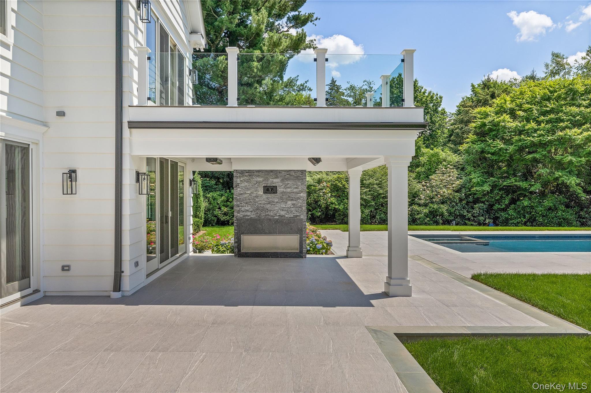 42 Mamaroneck Road Scarsdale, NY 10583 - Photo 6 of 47 Enjoy al fresco living beneath the heated covered porch featuring a dramatic outdoor fireplace, ceiling heaters, and wiring for a flat screen tv, all just steps from the pool.