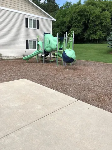 a view of a chair and table in backyard of the house