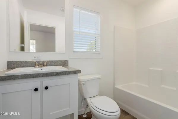 a bathroom with a granite countertop toilet a sink and a bathtub