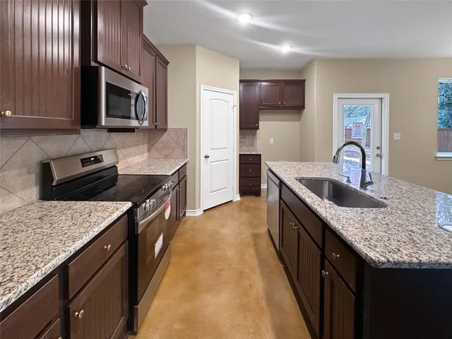 a kitchen with granite countertop stainless steel appliances and sink