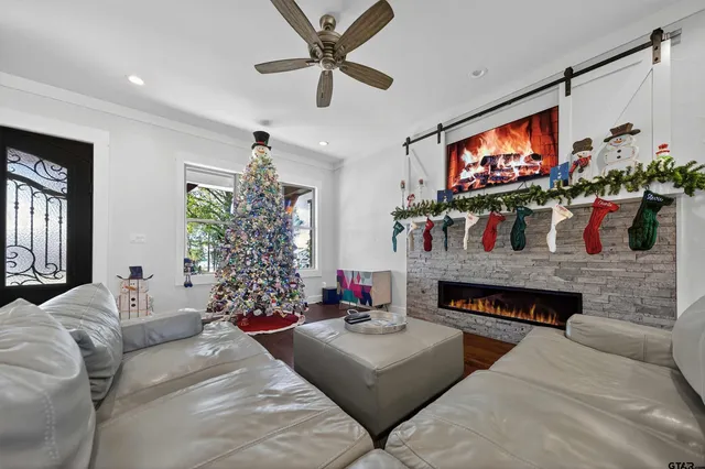 a living room with fireplace furniture a flat screen tv and a large window