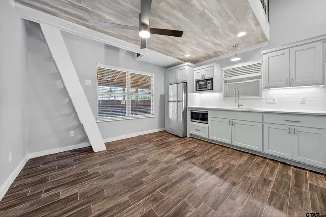 a kitchen with cabinets and wooden floor