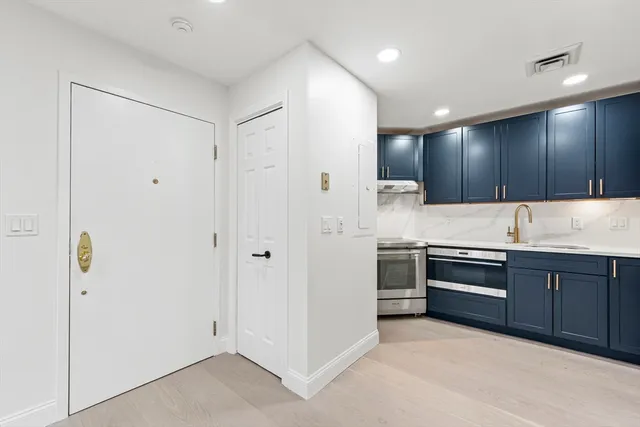 a kitchen with stainless steel appliances granite countertop a refrigerator and a sink