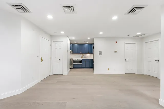 a view of an empty room with a kitchen