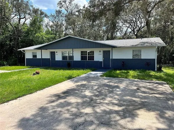 a front view of a house with yard and green space
