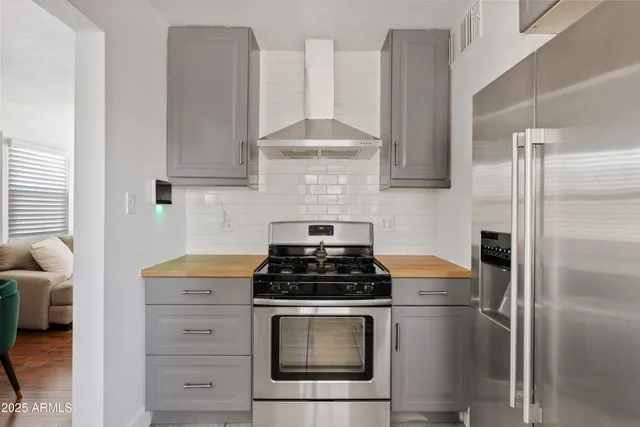 a kitchen with stainless steel appliances granite countertop a sink a stove a refrigerator and cabinets