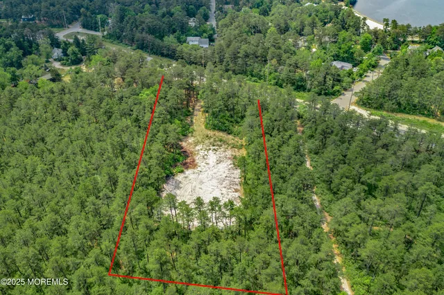 an aerial view of residential house with outdoor space and trees all around
