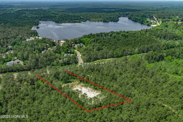 an aerial view of residential house with outdoor space and trees all around