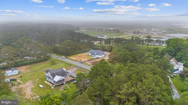 an aerial view of a house with yard swimming pool and lake view