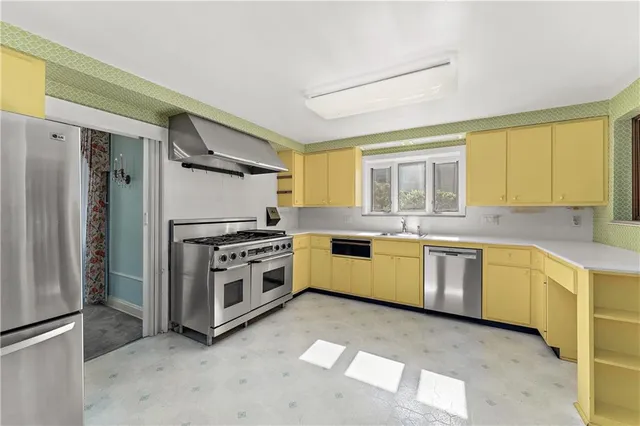 a kitchen with stainless steel appliances a stove a sink and a refrigerator