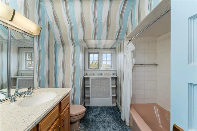 a view of an empty room with wooden floor and closet