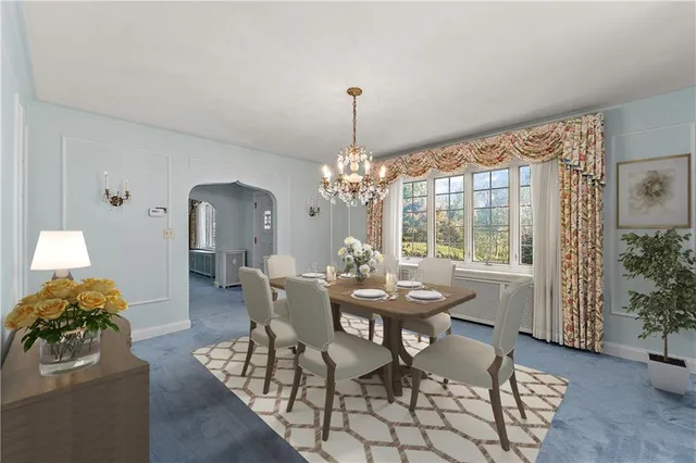 a dining room with furniture a chandelier and window