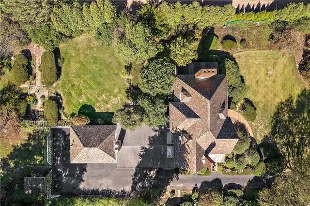a aerial view of a house with a yard and large trees