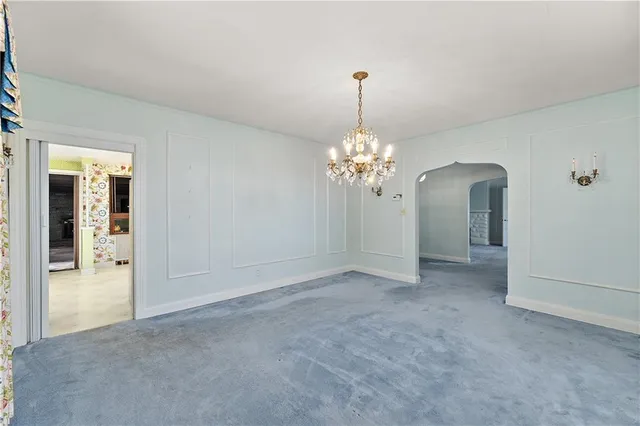 a view of a room with a chandelier fan and windows