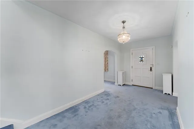 an empty room with chandelier fan