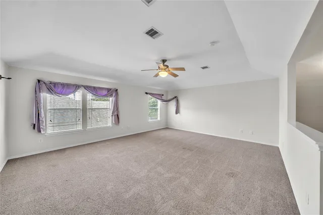a view of empty room with a kitchen