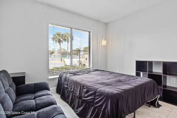 a bedroom with a bed couch and window