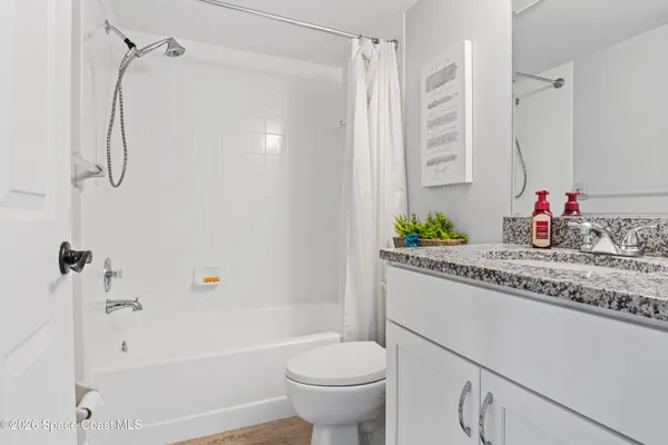 a bathroom with a granite countertop sink a toilet and a bathtub
