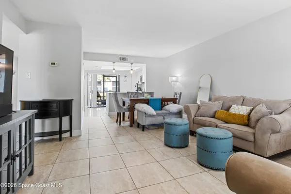 a living room with furniture and a view of kitchen