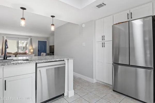 a kitchen with kitchen island a refrigerator a sink and a stove