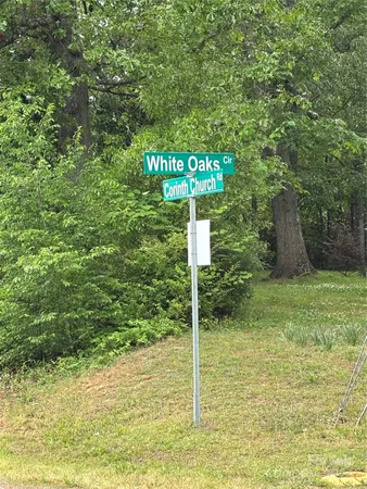 a sign that is sitting in front of a tree