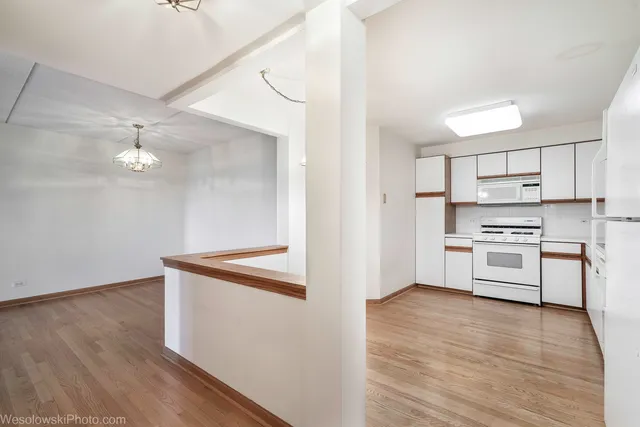 a kitchen with granite countertop white cabinets and white appliances