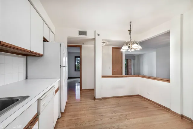 a view of a kitchen with a sink and refrigerator