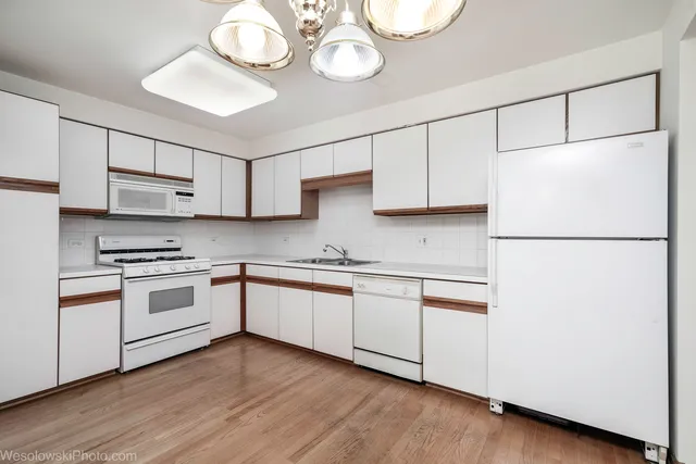 a kitchen with stainless steel appliances granite countertop a sink a stove a refrigerator and cabinets