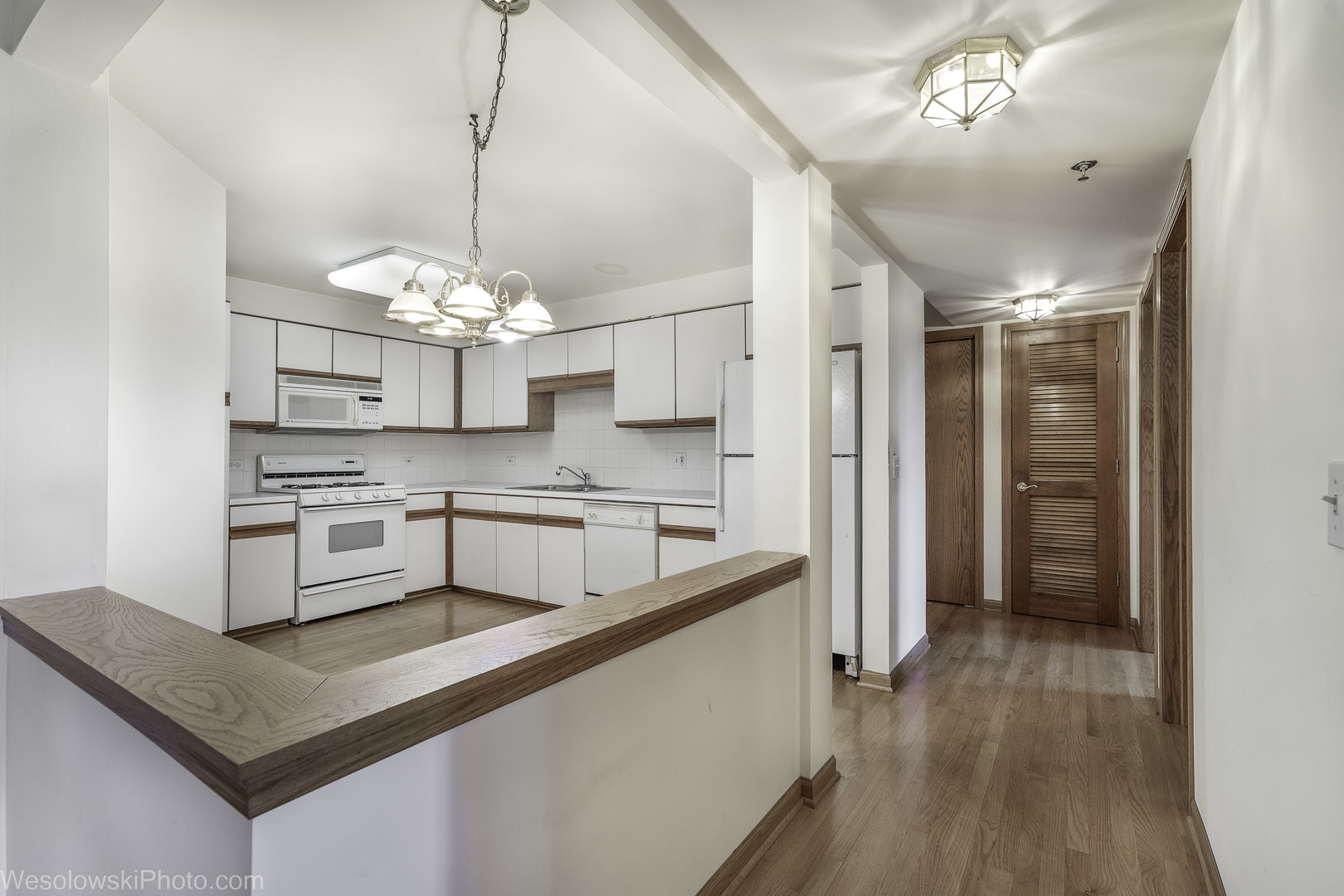 7450 Waukegan Road, Unit 206 Niles, IL 60714 - Photo 19 of 26 a kitchen with stainless steel appliances granite countertop a sink dishwasher a refrigerator and white cabinets with wooden floor