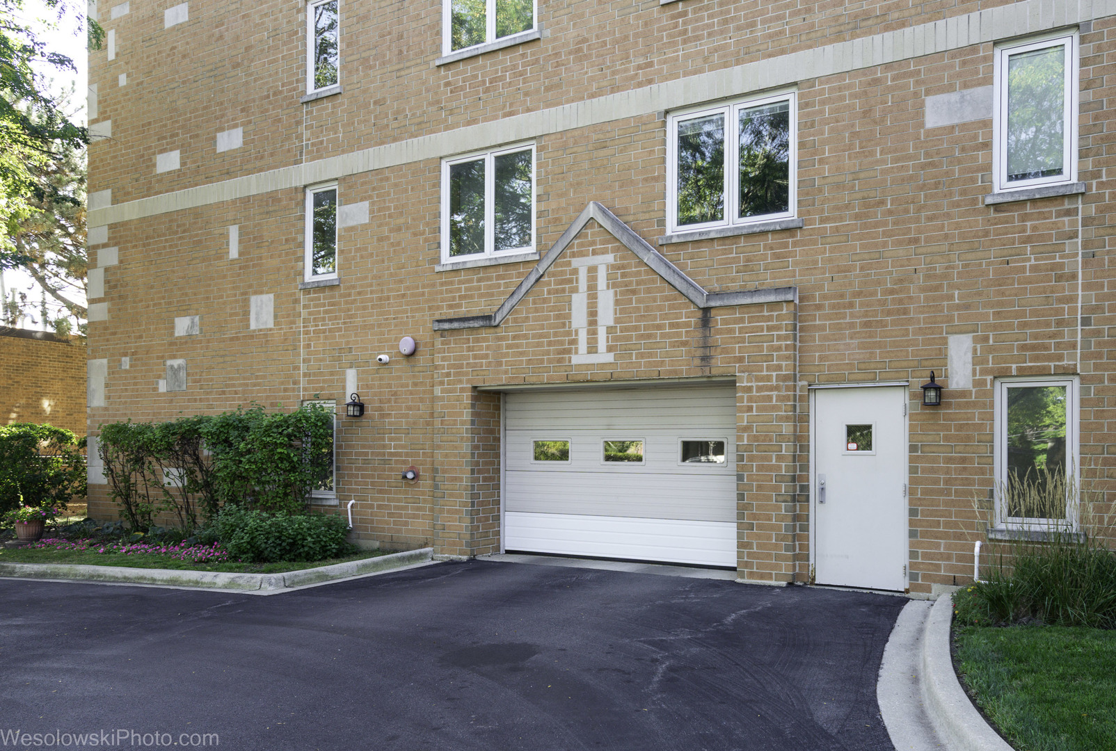 7450 Waukegan Road, Unit 206 Niles, IL 60714 - Photo 2 of 26 a front view of a house with a yard and garage