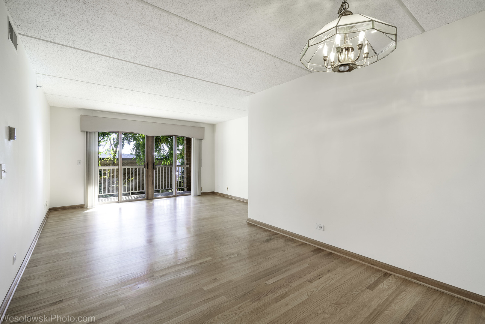 7450 Waukegan Road, Unit 206 Niles, IL 60714 - Photo 6 of 26 an empty room with wooden floor and windows