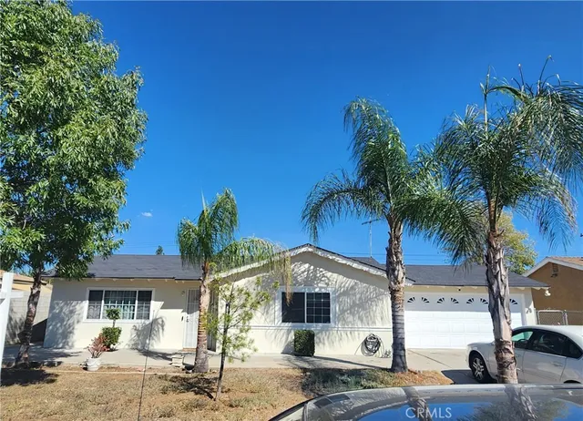 a front view of a house with palm trees